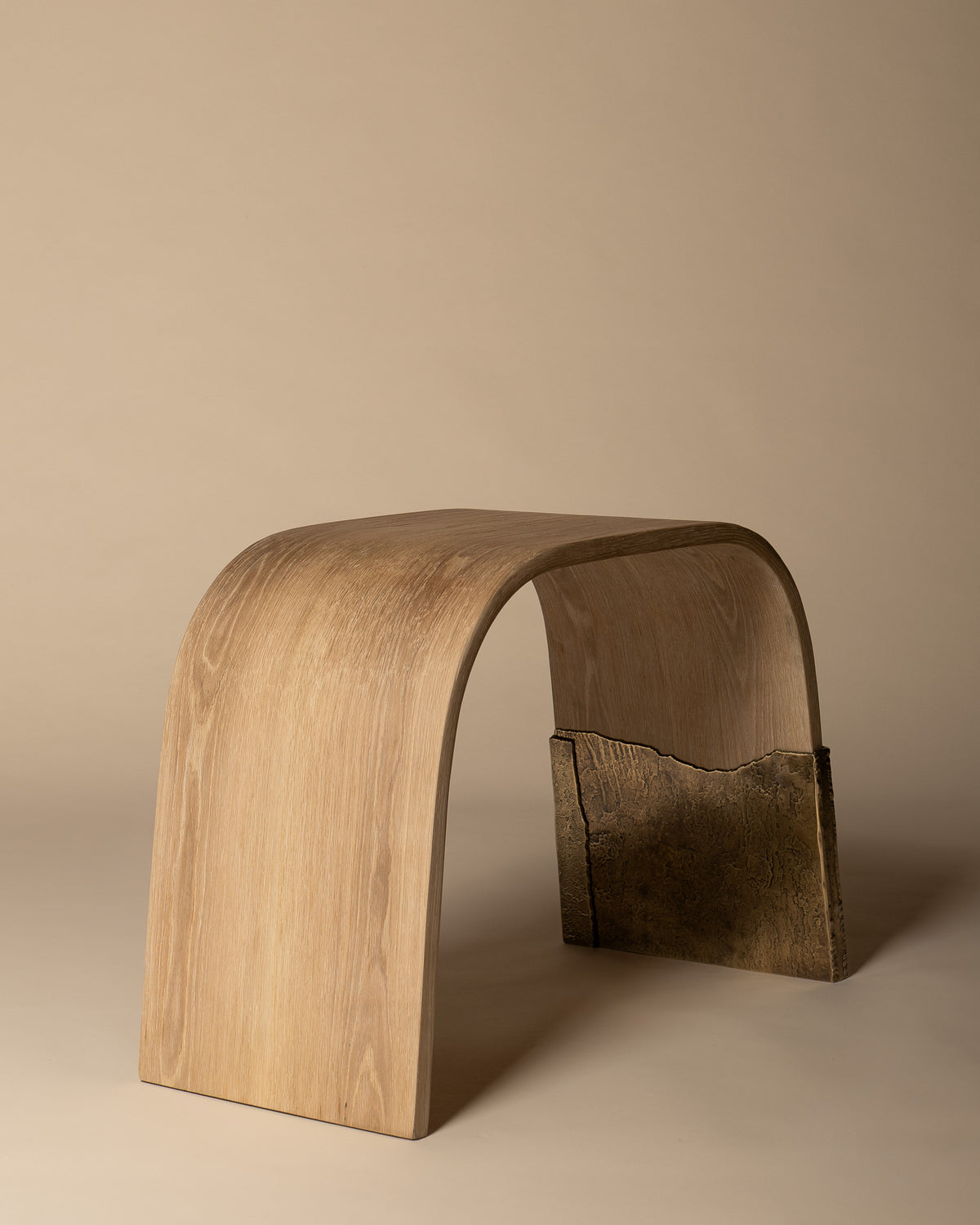 Brume bench from a low angle, showing the open space beneath the curved oak seat.