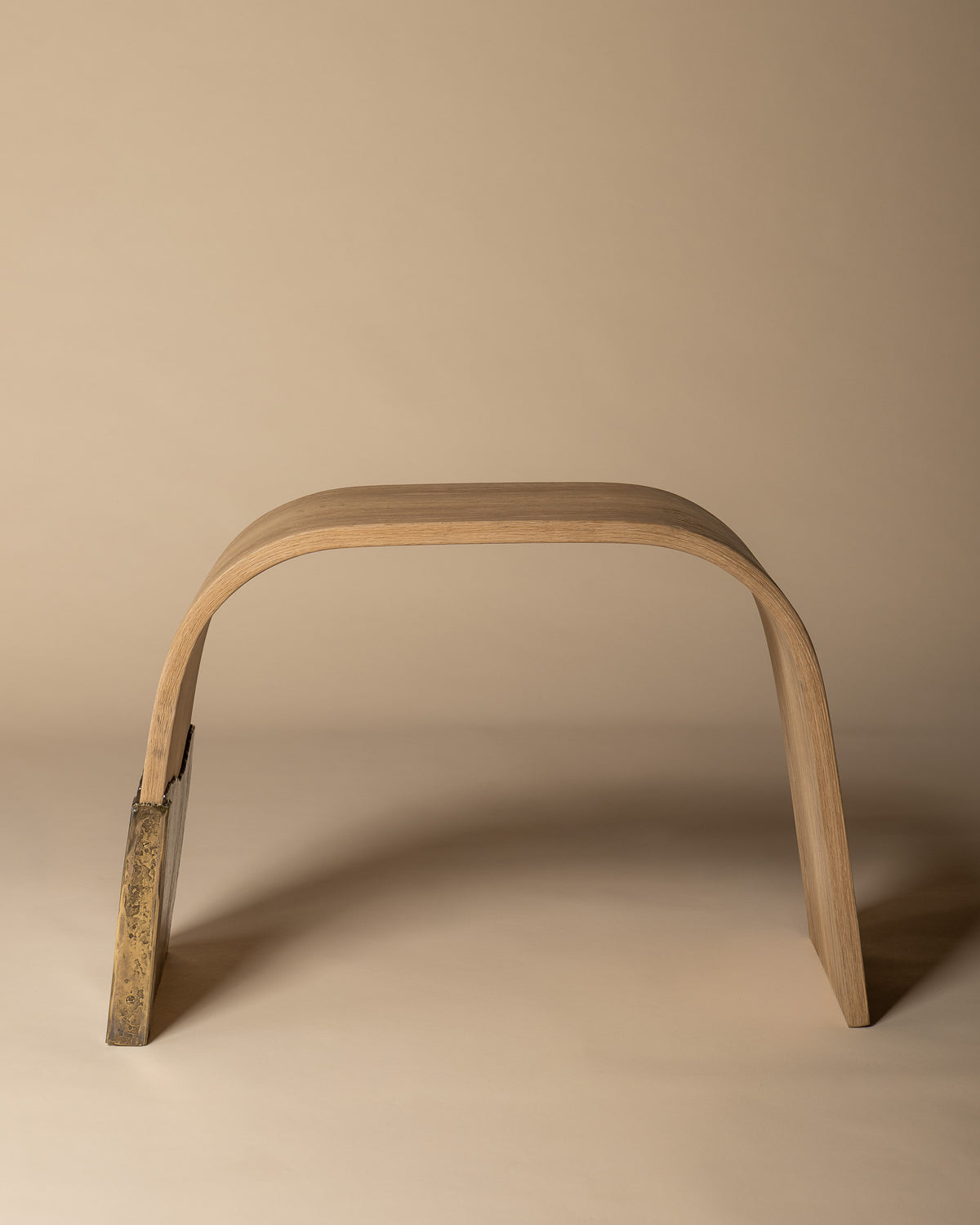 Brume bench in side profile, showing the arch of the oak seat.
