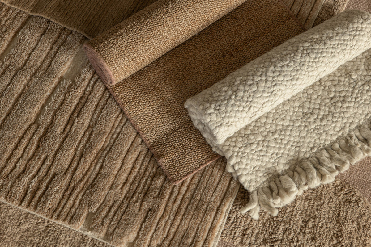 Layered rug samples in warm earth tones