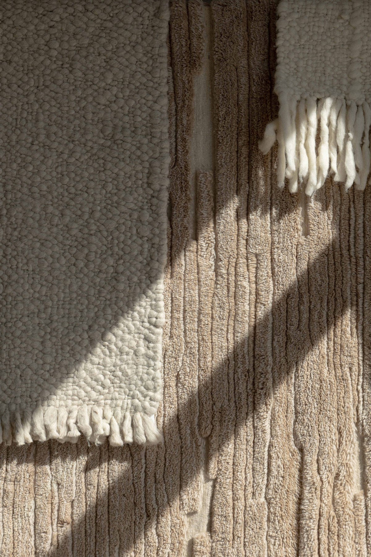 Sunlight and shadow across a textured rug