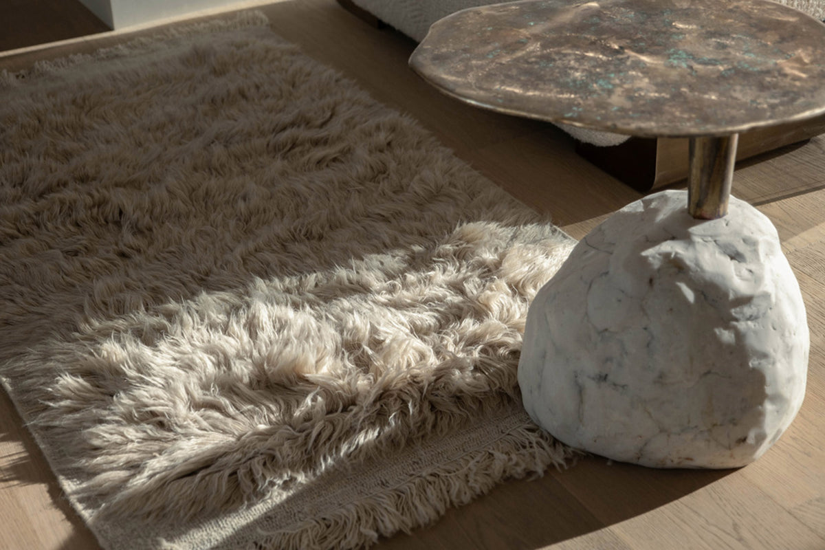 Soft rug texture beside a sculptural side table
