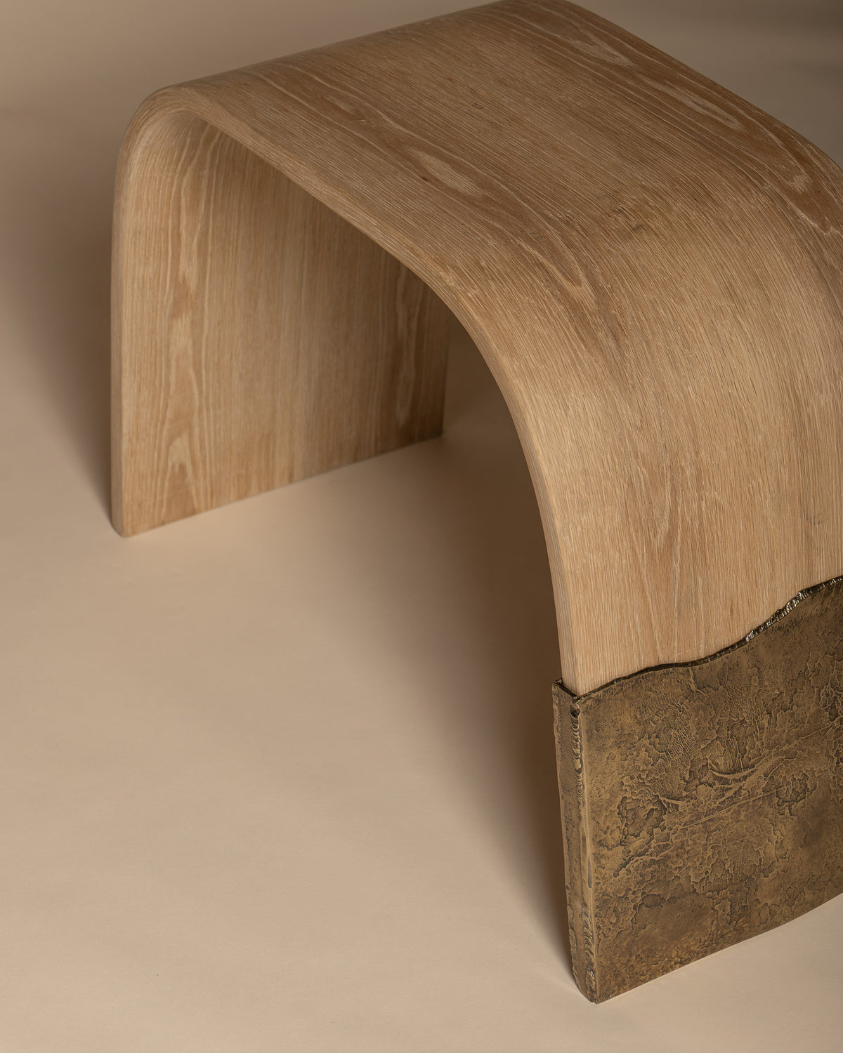 Brume bench from above and behind, showing the oak grain and brass leg.