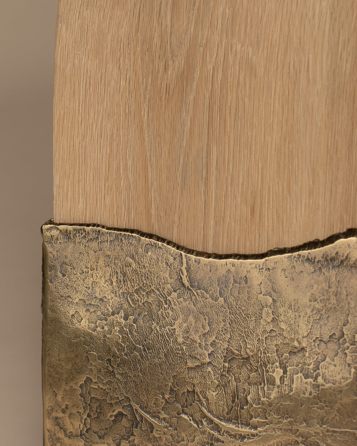Close-up of the boundary between Brume's oak and textured brass.