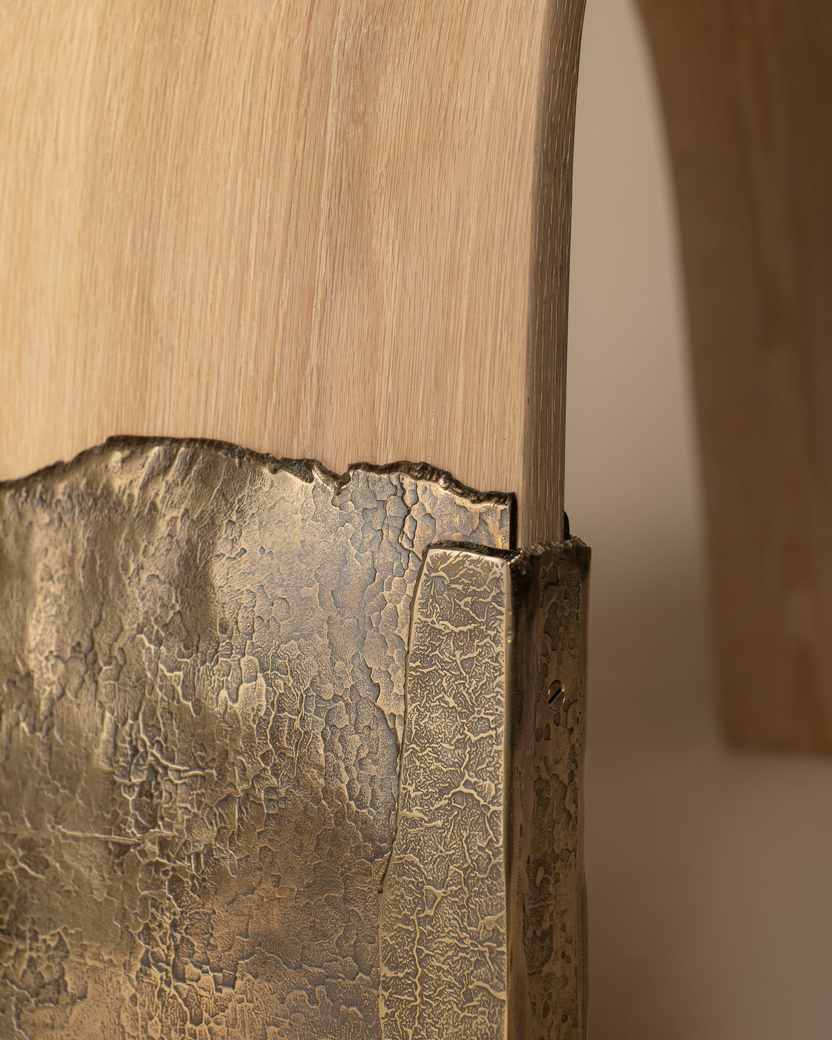 Detail of Brume's brass leg wrapping around the oak form.