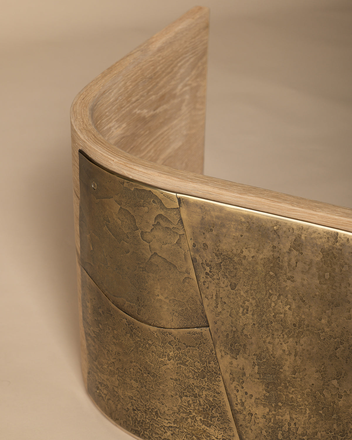 Close-up of Veil's curved oak edge beneath the brass seat.