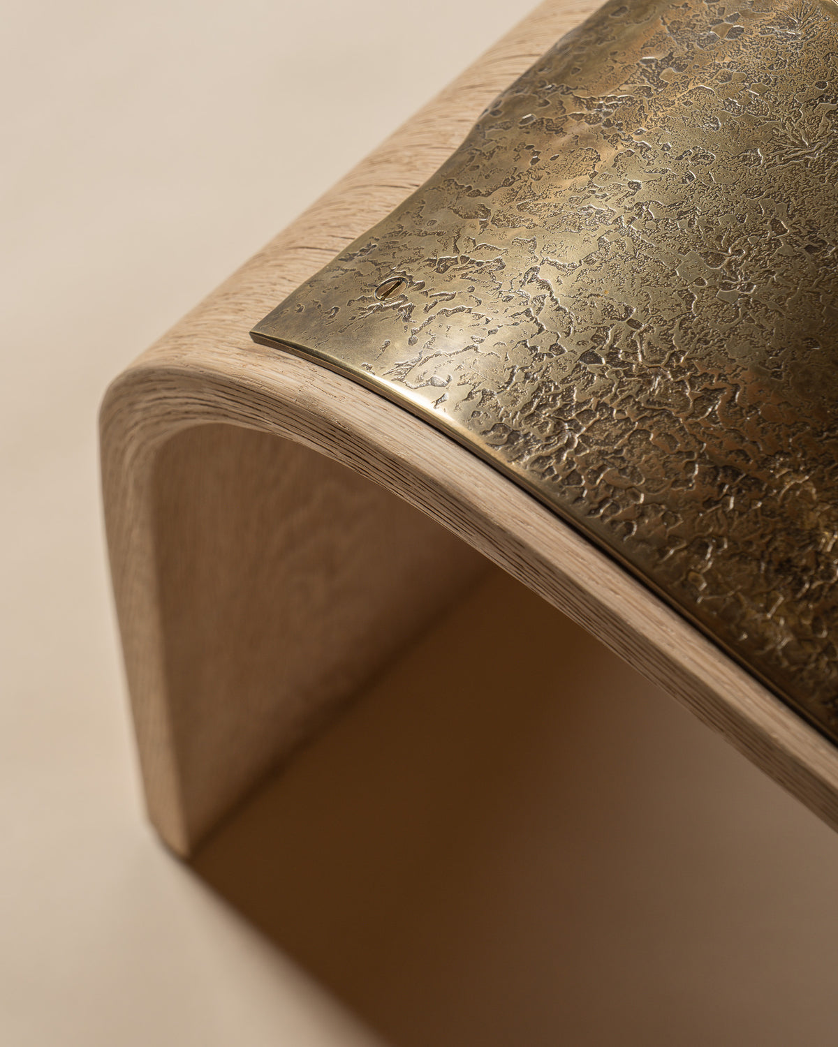 Veil bench viewed from above, showing the brass seat following the curve of the oak.
