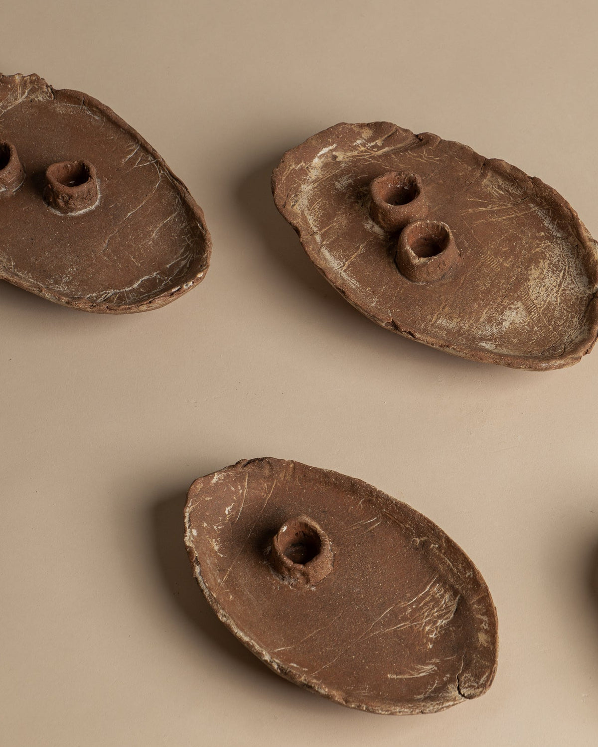 Two complete Utah Clay double candlesticks viewed from above, showing differences in handmade shape and surface, alongside single candlesticks. Sold individually.