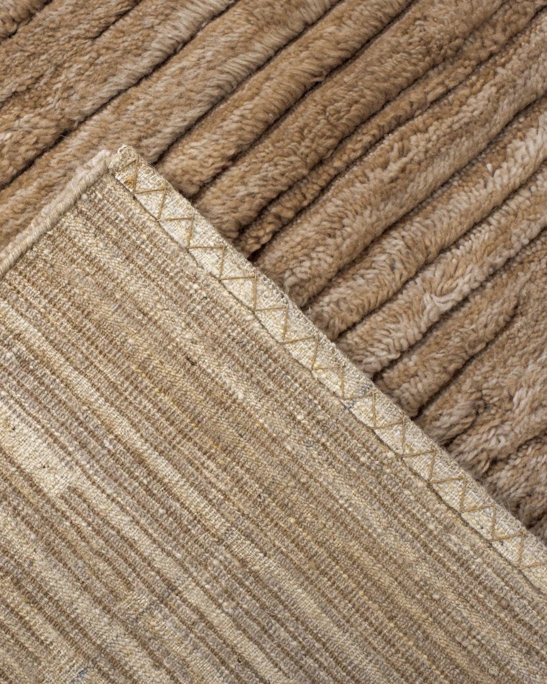 Placeholder photograph: folded rug corner showing the underside and edge stitching.